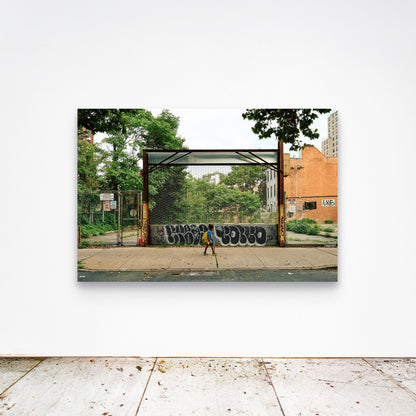 Chloe Albert's fine art print 'Boy Walking' shown unframed at 60 by 40 inches on a gallery wall above a concrete floor, displaying the large statement size in a room.