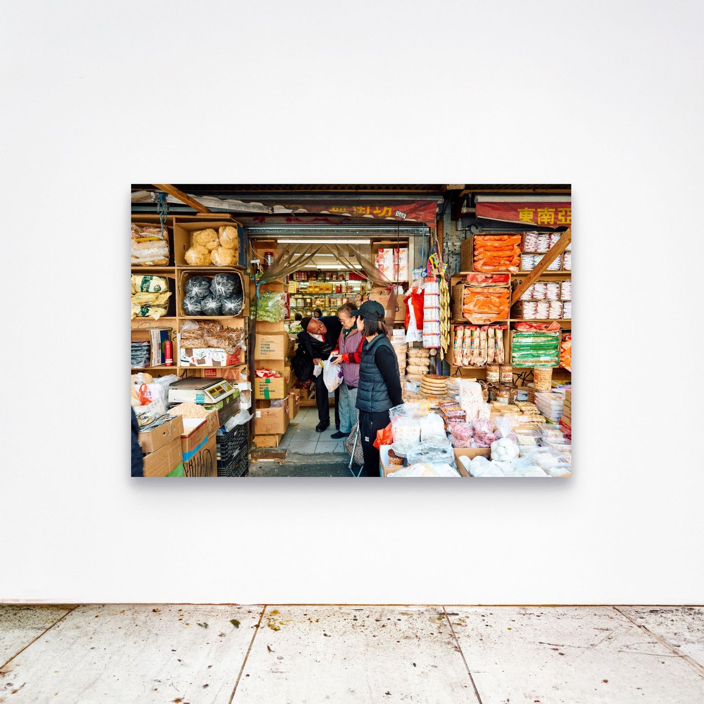 Chloe Albert's fine art print 'Chinatown' shown unframed at 60 by 40 inches on a gallery wall above a concrete floor, displaying the large statement size in a room.