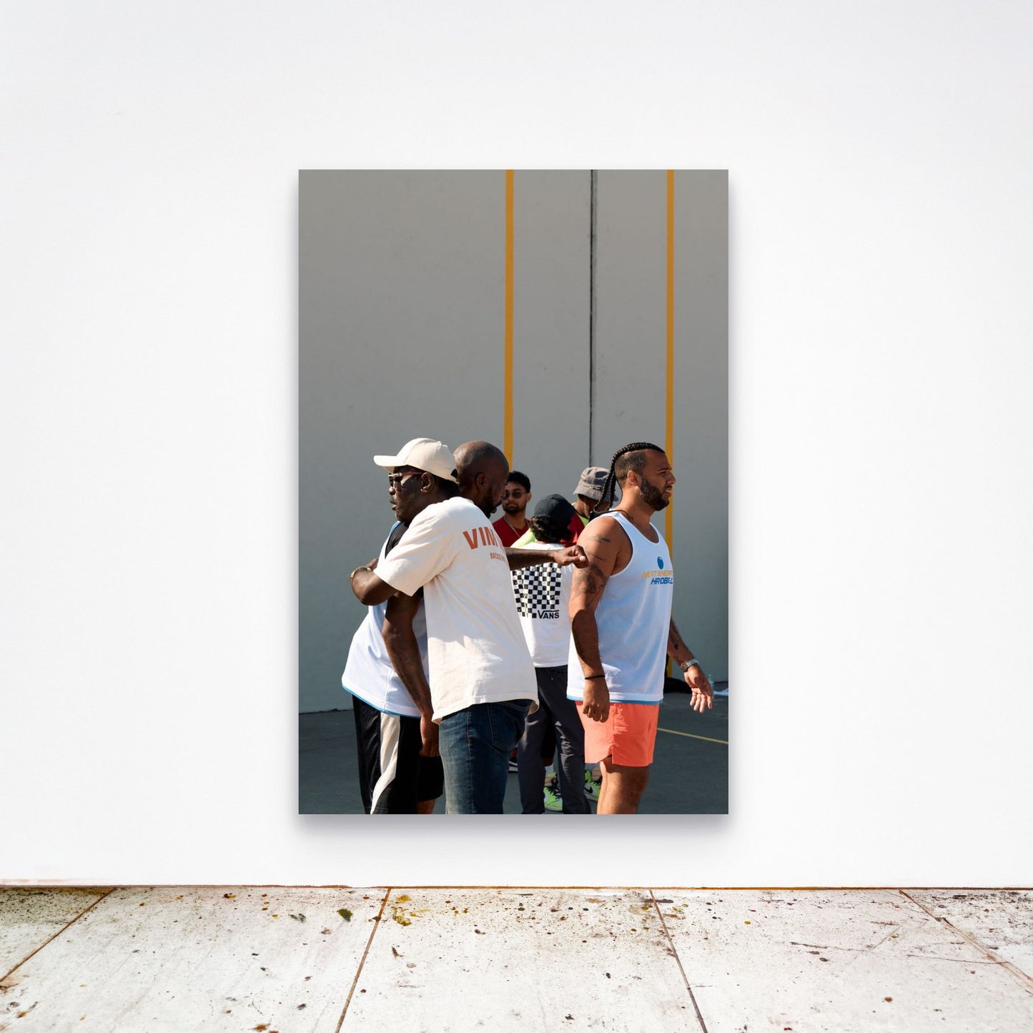 Chloe Albert's fine art print 'Chosen Family' shown unframed at 60 by 40 inches on a gallery wall above a concrete floor, displaying the large statement size in a room.