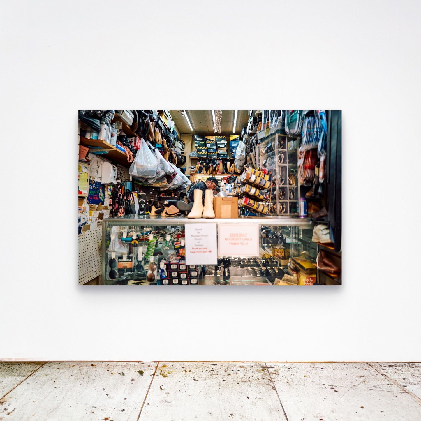 Chloe Albert's fine art print 'Cobbler' shown unframed at 60 by 40 inches on a gallery wall above a concrete floor, displaying the large statement size in a room.
