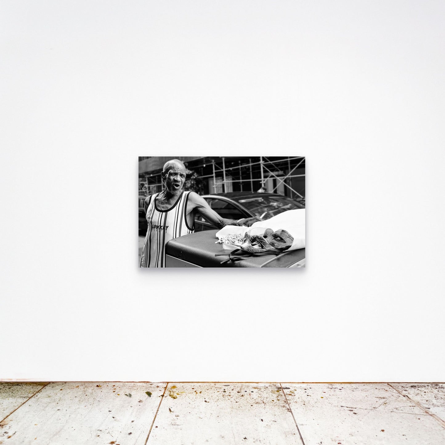 Chloe Albert's fine art print 'Mask Seller' shown unframed at 36 by 24 inches on a gallery wall, displaying the print at scale in a room setting.