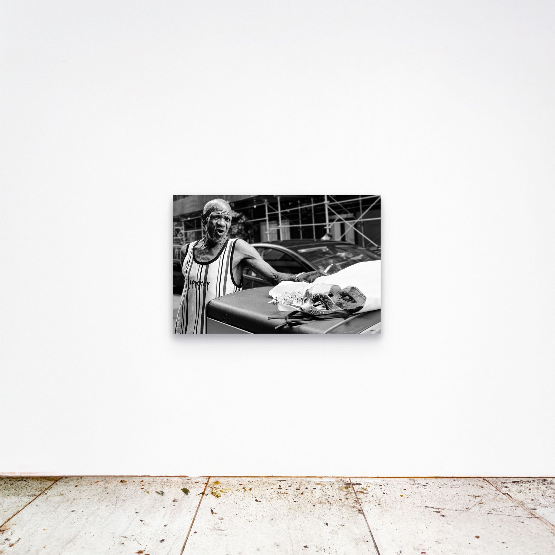 Chloe Albert's fine art print 'Mask Seller' shown unframed at 36 by 24 inches on a gallery wall, displaying the print at scale in a room setting.