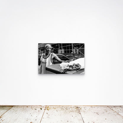Chloe Albert's fine art print 'Mask Seller' shown unframed at 36 by 24 inches on a gallery wall, displaying the print at scale in a room setting.