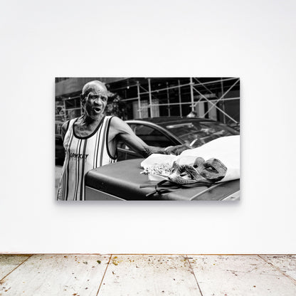 Chloe Albert's fine art print 'Mask Seller' shown unframed at 60 by 40 inches on a gallery wall above a concrete floor, displaying the large statement size in a room.