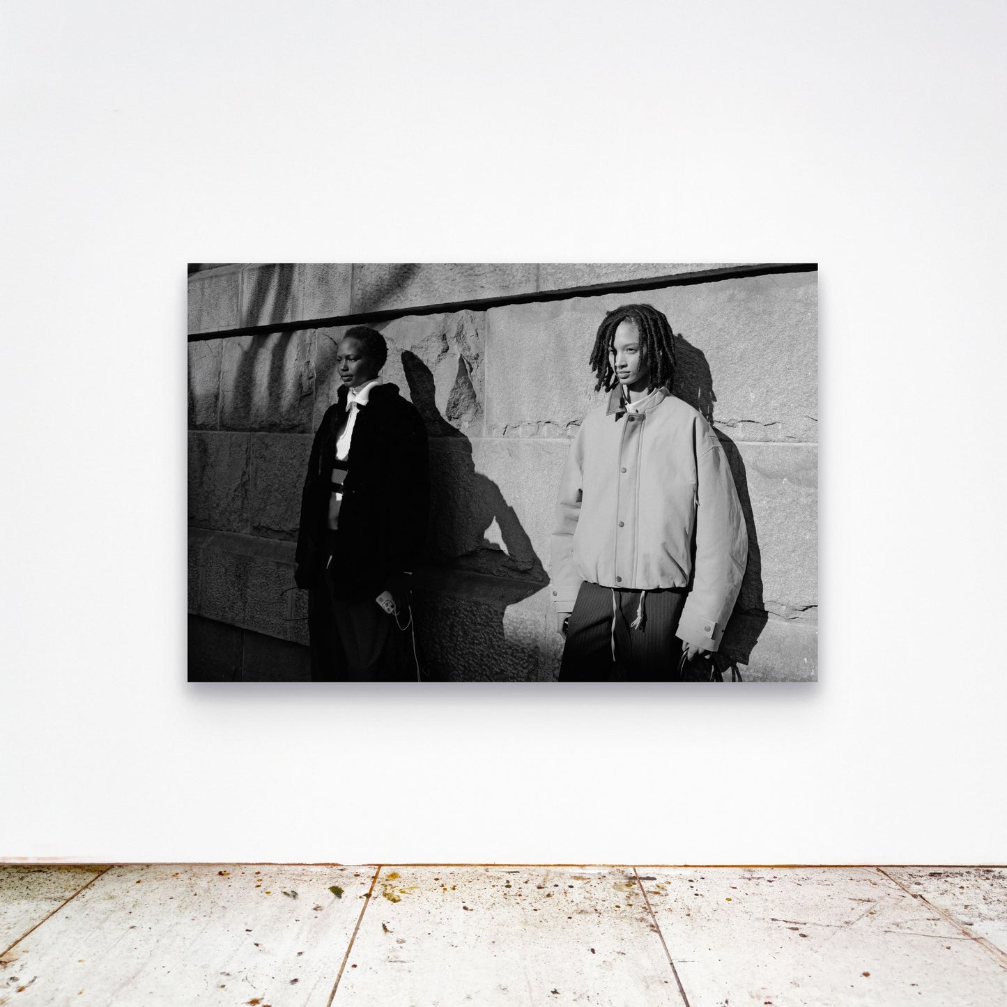 Chloe Albert's fine art print 'Models' shown unframed at 60 by 40 inches on a gallery wall above a concrete floor, displaying the large statement size in a room.