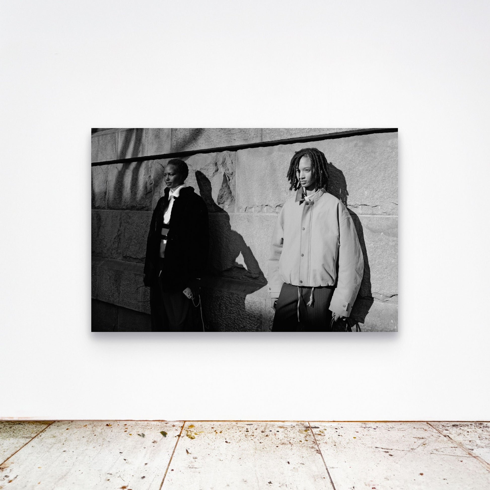 Chloe Albert's fine art print 'Models' shown unframed at 60 by 40 inches on a gallery wall above a concrete floor, displaying the large statement size in a room.