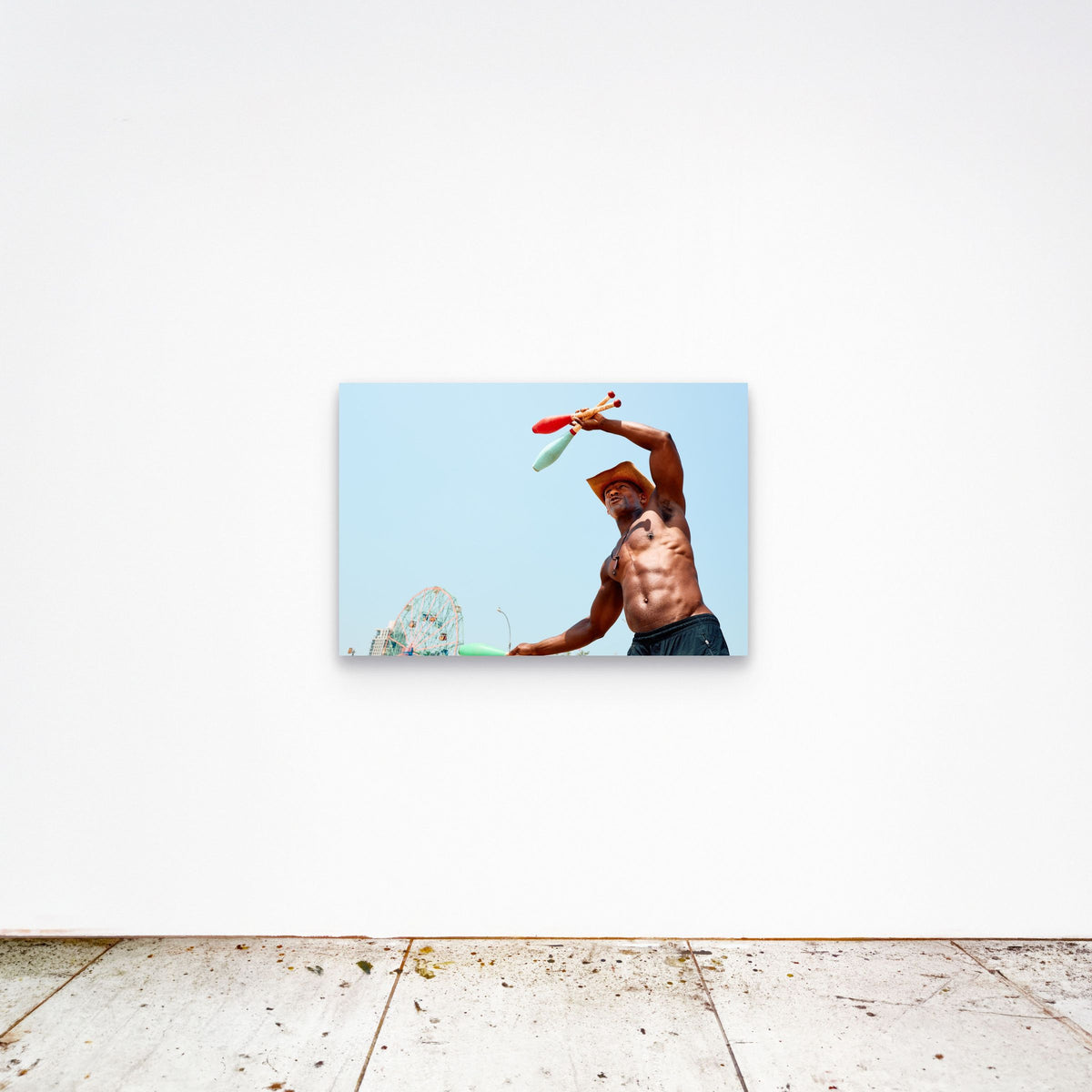 Chloe Albert's fine art print 'The Juggler' shown unframed at 36 by 24 inches on a gallery wall, displaying the print at scale in a room setting.